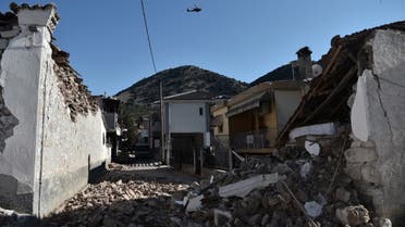 An army helicopter flies over collapsed buildings in the village of Damasi, near the town of Tyrnavos, after a strong 6,3-magnitude earthquake hit the Greek central region of Thessaly on March 3, 2021. (AFP)