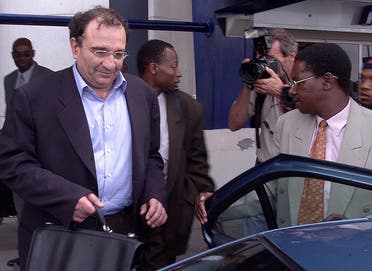 A file photo shows Ari Ben Menashe, an Israeli-Canadian consultant, is hustled into a car by Zimbabwe security personnel shortly after his arrival at Harare International Airport, Friday Feb. 22, 2002. (AP)
