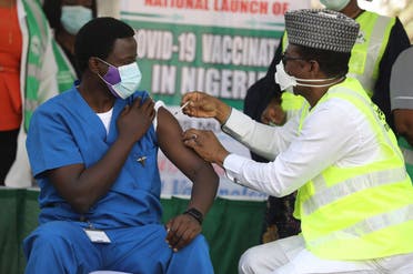 Dr. Ngong Cyprian (L), the first Nigerian to receive the first dose of the Oxford/AstraZeneca vaccine at the National Hospital Abuja, Nigeria on March 5, 2021. (Kola Sulaimon/AFP)