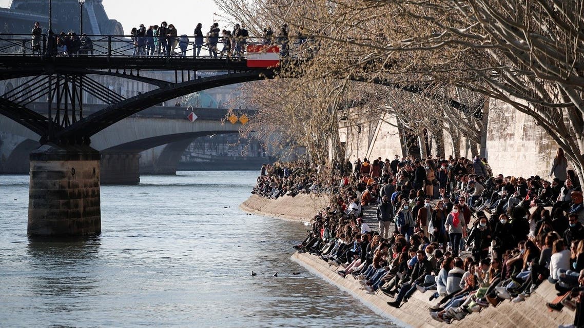 People sit along the Seine river, amid the coronavirus disease (COVID-19) outbreak, in Paris, France, February 28, 2021. (Reuters/Benoit Tessier)
