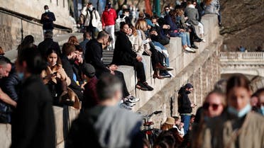 People sit near the Seine river, amid the coronavirus disease (COVID-19) outbreak, in Paris, France, February 28, 2021. (Reuters/Benoit Tessier)