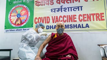 This handout photograph taken on March 6, 2021 and released by the Office of His Holiness the Dalai Lama (OHHDL) shows the exiled Tibetan spiritual leader Dalai Lama getting inoculated with the Covid-19 coronavirus vaccine by a health worker at a vaccination center in Dharamsala.
