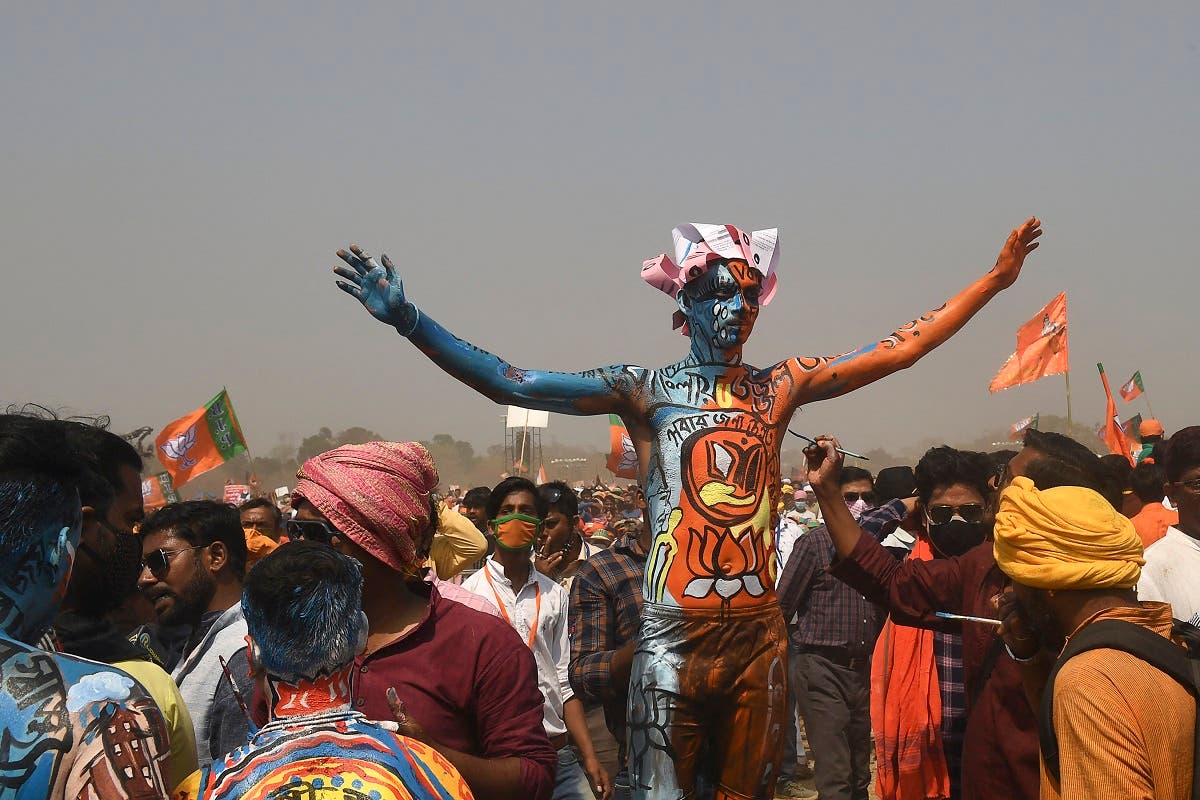 A Bharatiya Janata Party (BJP) supporter with his body painted gestures during a mass rally addressed by India's PM Modi at the Brigade Parade ground in Kolkata on March 7, 2021. (Dibyangshu Sarkar/AFP)