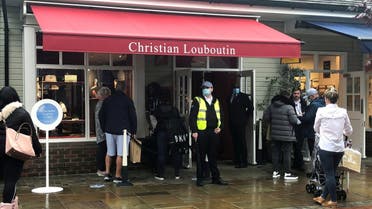 Shoppers are seen queuing outside the Christian Louboutin shop at Bicester Village,  in Bicester, Britain. (Reuters)