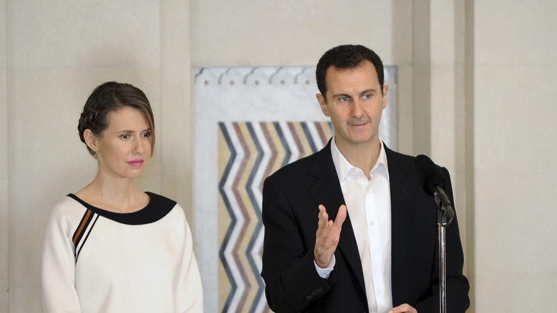 Syria's President Bashar al-Assad stands next to his wife Asma