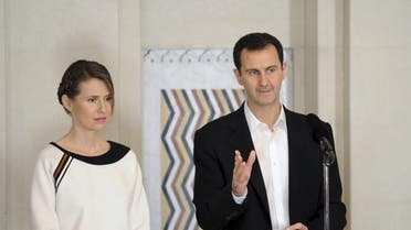 Syria's President Bashar al-Assad stands next to his wife Asma