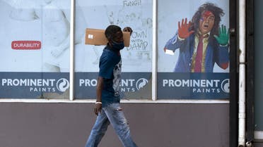 A man wearing a face mask to protect against the spread of the coronavirus walks past a paint advertisement in Alberton, east of Johannesburg, South Africa, Monday, March 1, 2021. (File photo: AP)
