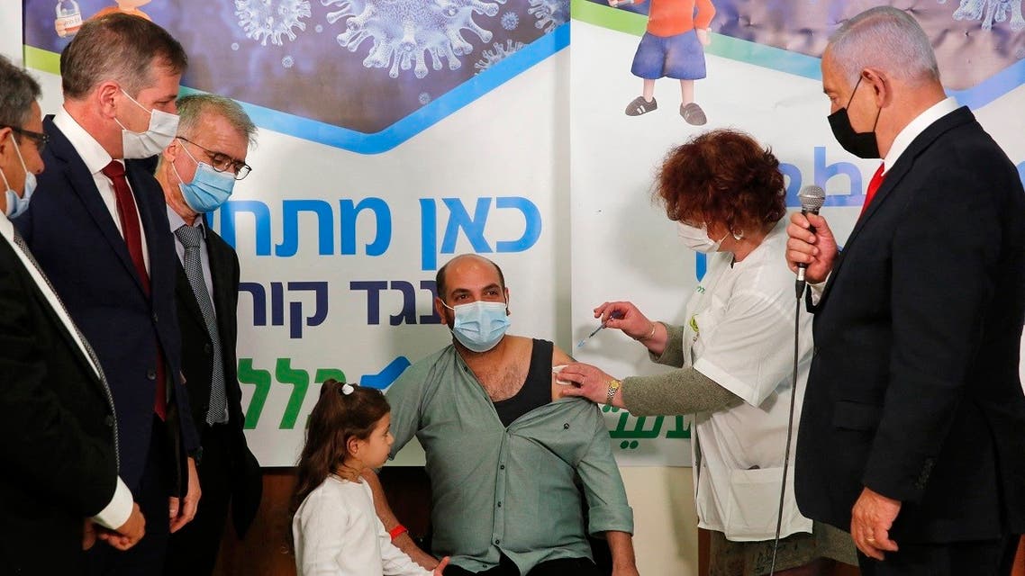 Israeli Prime Minister Benjamin Netanyahu (C) speaks during a visit at Clalit Health Service as an Israeli citizen receives a shot of the Covid-19 vaccine, in an Arab-Israeli village of Abu Ghosh near Jerusalem on March 9, 2021. (Gil Cohen-Magen/AFP)