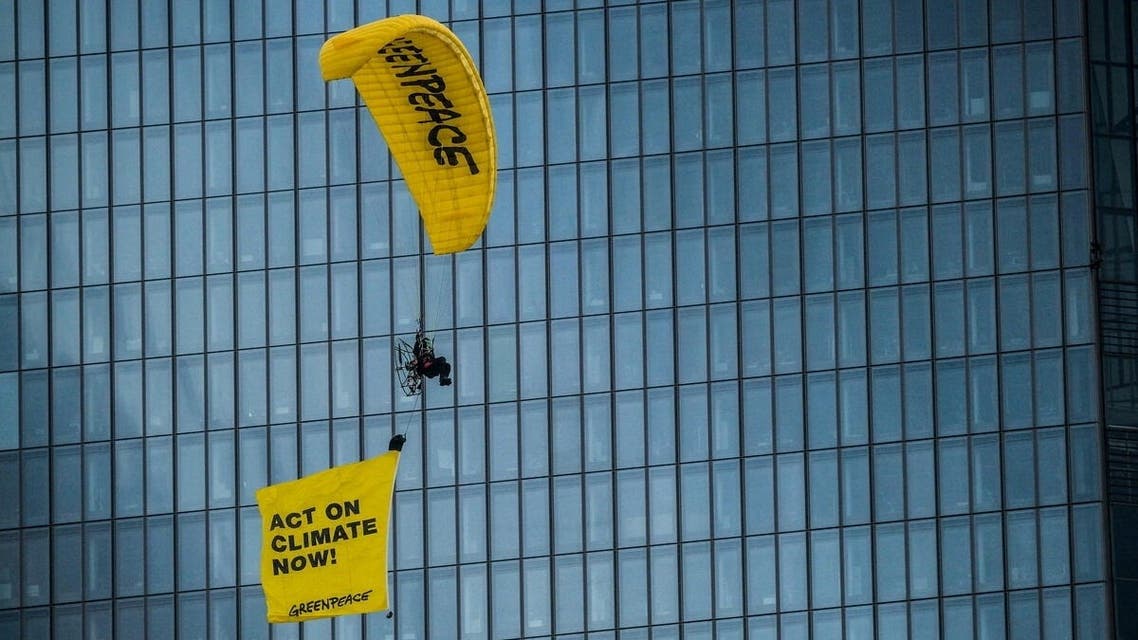 An activist on a paraglider protests with a flying banner, in Frankfurt, Germany March 10, 2021. (Reuters)