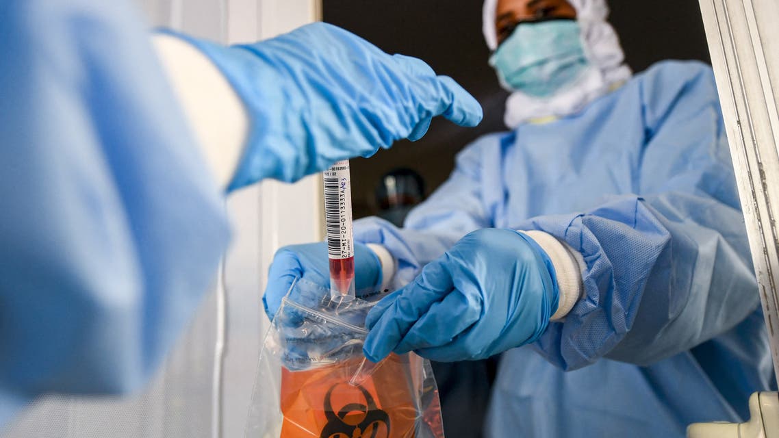 Laboratory workers bag a biological sample at a drive-through COVID-19 coronavirus testing centre in al-Khawaneej district of the gulf emirate of Dubai, UAE. (File photo: AFP)