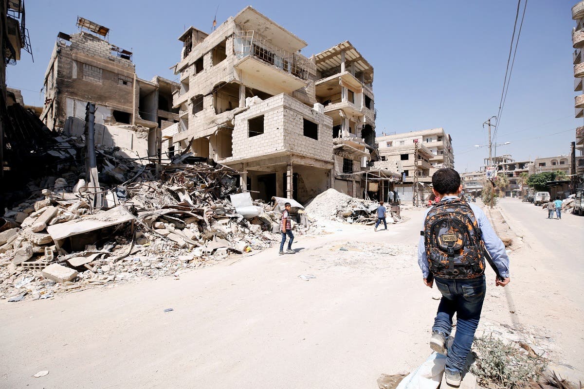 A student walks along a damaged street in the town of Kafr Batna, in eastern Ghouta, Syria. (File Photo: Reuters)