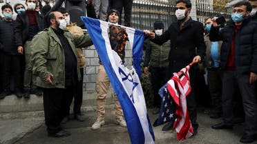 Iranians burn US and Israeli flags during a demonstration against the killing of Mohsen Fakhrizadeh, Iran's top nuclear scientist, in Tehran, Nov. 28, 2020. (Reuters)