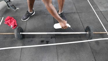 A man cleans a training bar before use at the Fitness 360 gym in Nairobi on August 10, 2020, in line with the safety regulations against COVID-19. (File photo: AFP)