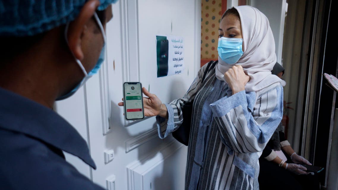 Saudi Hala Abdullah shows her page on the Tawakkalna app, which was launched by Saudi authorities last year to help track coronavirus infections, as she enters a shop in Jiddah, Saudi Arabia, Friday, Feb. 5, 2021. (File photo: AP)