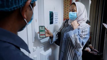 Saudi Hala Abdullah shows her page on the Tawakkalna app, which was launched by Saudi authorities last year to help track coronavirus infections, as she enters a shop in Jiddah, Saudi Arabia, Friday, Feb. 5, 2021. (File photo: AP)