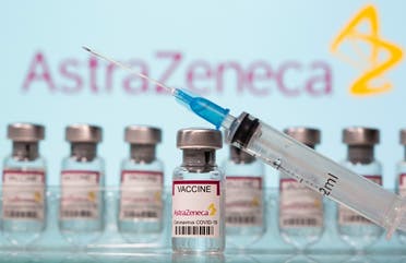 Vials labelled AstraZeneca COVID-19 Coronavirus Vaccine and a syringe are seen in front of a displayed AstraZeneca logo. (Reuters)