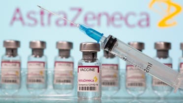 Vials labelled AstraZeneca COVID-19 Coronavirus Vaccine and a syringe are seen in front of a displayed AstraZeneca logo. (Reuters)