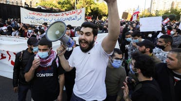 A demonstrator gestures while carrying a megaphone during a protest against the fall in Lebanese pound currency and mounting economic hardships, in Beirut, Lebanon March 12, 2021. (Reuters)