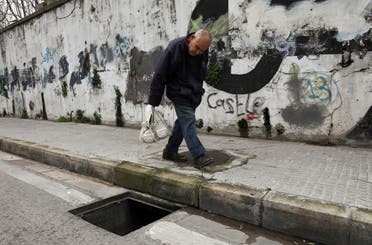A man walks past a manhole with a missing cover in Beirut, Lebanon March 4, 2021. (Reuters)