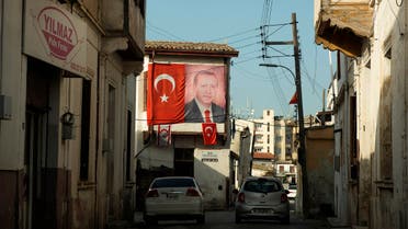 A portrait of Turkish President Recep Tayip Erdogan and Turkish flags are seen on a building in the Turkish occupied area at the Turkish Cypriot breakaway north part of divided capital Nicosia, Cyprus, Wednesday, March 10, 2021. A group representing Greek Cypriot and Turkish Cypriot left-wing peace organizations on Friday, March 12, condemned the arrest of four Turkish Cypriot activists for allegedly damaging signs in breakaway northern Cyprus professing adoration for Turkish President Recep Tayip Erdogan. (AP Photo/Nedim Enginsoy)