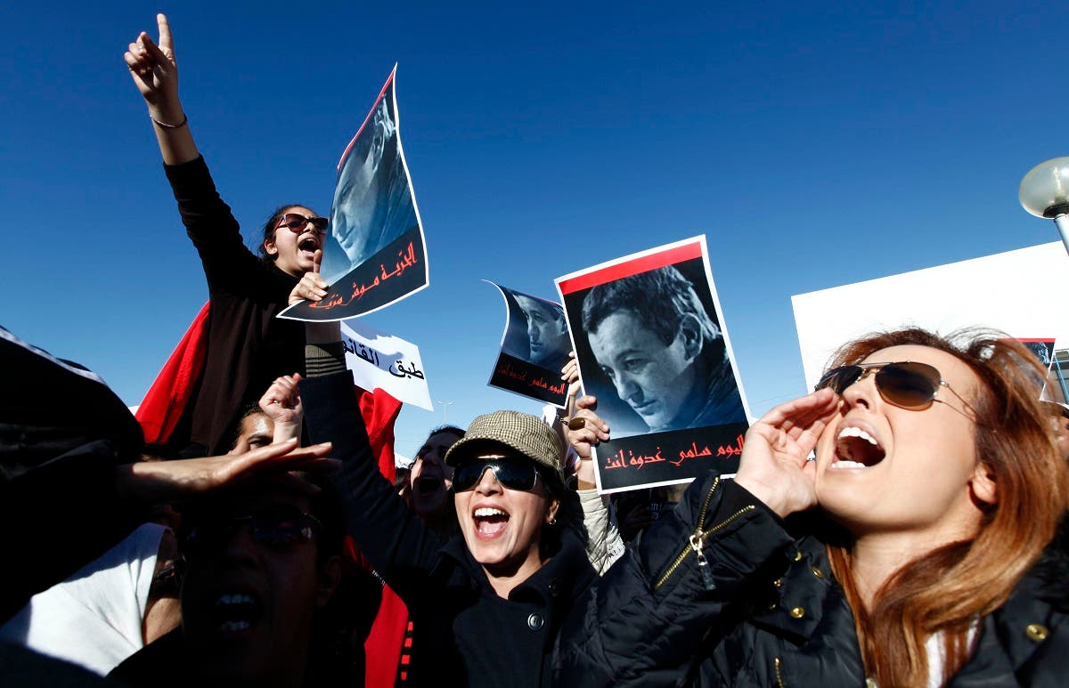 Tunisian protesters hold posters depicting Sami Fehri, TV producer and director of Ettounsiya Television, during a demonstration outside Mornaguia jail calling for the liberation of Fehri, in Tunis December 24, 2012. (Reuters)