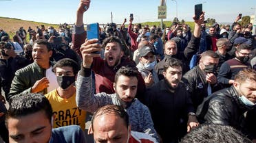 People protest outside al-Hussein New Salt Hospital in the town of Salt, northwest of Jordan's capital, on March 13, 2021. (AFP)