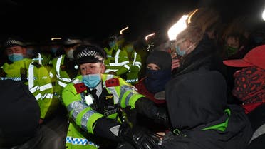 Police scuffle with people gathering at the band-stand where a planned vigil in honor of murder victim Sarah Everard, which was officially cancelled due to COVID-19 restrictions, was to take place on Clapham Common, south London on March 13, 2021. (AFP)