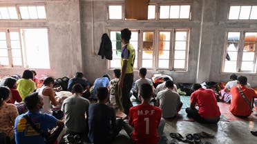Myanmarese policemen, who fled Myanmar and crossed illegally to India, sit in a temporary shelter at an undisclosed location in India's northeastern state of Mizoram on March 13, 2021. (AFP)