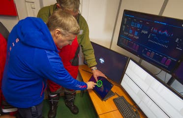 This handout picture released on March 13, 2021 shows scientists and officials checking a screen during an operation to immerge the underwater neutrino telescope into the water of the Baikal lake. (Bair Shaibonov/Russian Institute for Nuclear Research/AFP)