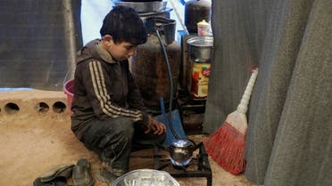 Mohammed Abu Rdan prepares tea inside a tent, at an internally displaced Syrian camp, in northern Aleppo, Syria March 11, 2021. (Reuters/Mahmoud Hassano)