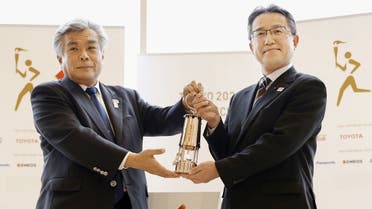 Makoto Noji, head of bureau of culture and sports for Fukushima government, holds the Olympic Flame in lantern with Tokyo 2020 COO Yukihiko Nunomura during an official ceremony at the J-Village National Training Center, in Naraha Town, Fukushima Prefecture, Japan, on April 1, 2020. (Reuters)