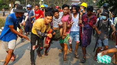 A resident, who was injured during a crackdown by security forces on demonstrations by protesters against the military coup, is carried to safety in Yangon's Hlaing Tharyar township on March 14, 2021. (STR/AFP)