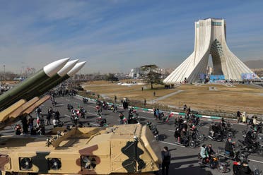 Iranians drive past missiles on motorcycles during a rally marking the 42nd anniversary of the Islamic Revolution, at Azadi (Freedom) Square in Tehran, Iran, on February 10, 2021. (AP)