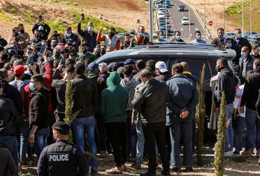 Angry people prevent passage to the vehicle of parliamentarians as it approaches al-Hussein New Salt Hospital in the town of Salt, northwest of Jordan's capital, on March 13, 2021. (AFP)