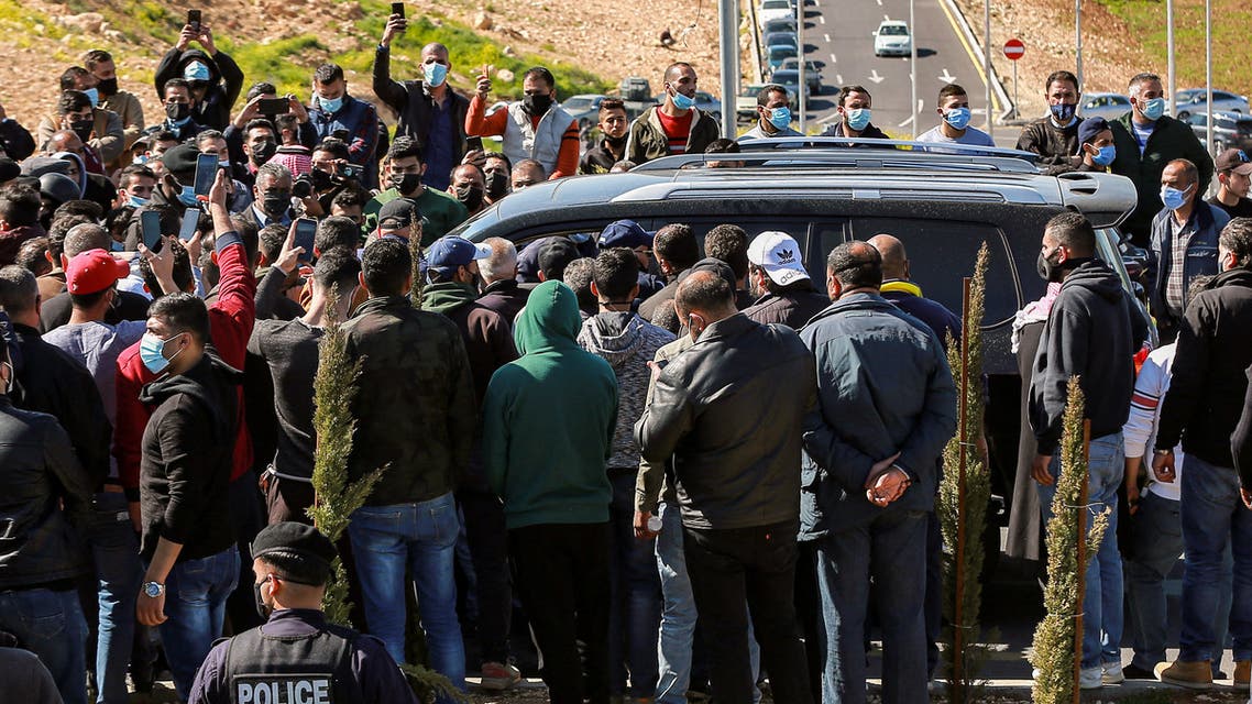 Angry people prevent passage to the vehicle of parliamentarians as it approaches al-Hussein New Salt Hospital in the town of Salt, northwest of Jordan's capital, on March 13, 2021. (AFP)