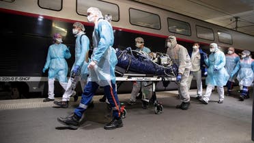 Medics embark a patient infected with the COVID-19 onboard a TGV high speed train at the Gare d’Austerlitz train station, from Paris region hospitals to Brittany, France, April 1, 2020. (Thomas Samson/Pool via Reuters)
