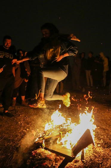 An Iranian jumps over the bonfire in Tehran on March 16, 2021 during the Wednesday Fire feast, or Chaharshanbeh Soori, held annually on the last Wednesday eve before the Spring holiday of Noruz. (AFP)