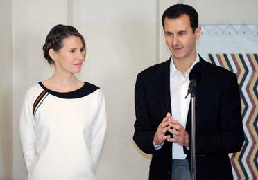 A file photo shows Syrian President Bashar al-Assad (R) speaking next to his wife Asma in the capital Damascus on March 21, 2016. (Stringer/SANA/AFP)