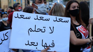 مواطنون يرفعون يافطة ضد عودة سعد الحريري للحكومة (أرشيفية- أسوشييتد برس)