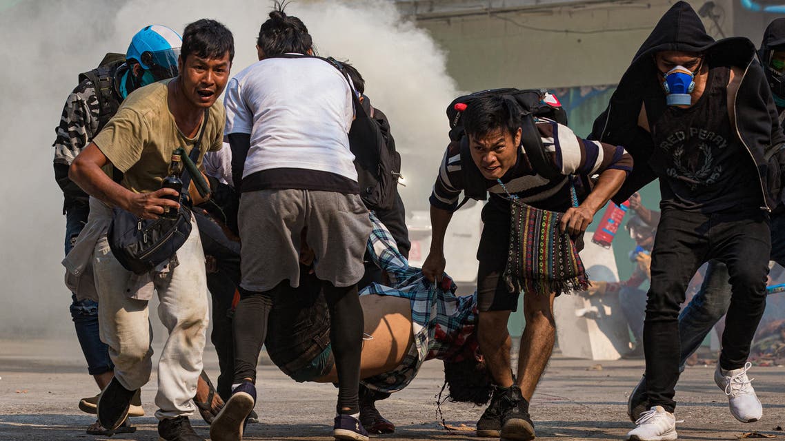 Protesters carry a wounded man shot with live rounds by security forces during a crackdown on demonstrations against the military coup in Yangon on March 17, 2021 (File photo: AFP).