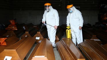 Cemetery workers disinfect coffins at an improvised morgue for coronavirus disease (COVID-19) victims at the Bare cemetery in Sarajevo, Bosnia and Herzegovina March 19, 2021. REUTERS/Dado Ruvic