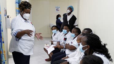 A health worker talks to her colleagues as they prepare to receive the AstraZeneca/Oxford vaccine under the COVAX scheme against coronavirus disease (COVID-19) at the Kenyatta National Hospital in Nairobi, Kenya March 5, 2021. (Reuters/Monicah Mwangi)