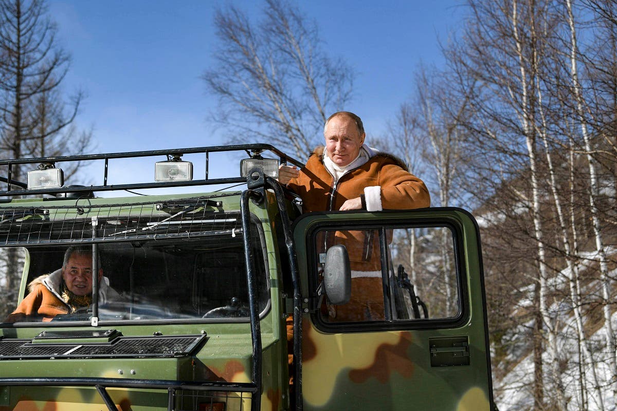 Russian President Vladimir Putin drives a tracked all-terrain vehicle as Russia Defense Minister Sergei Shoigu sits inside, in a taiga forest in Russia's Siberian. (Alexei Druzhinin, Sputnik, Kremlin Pool Photo via AP)