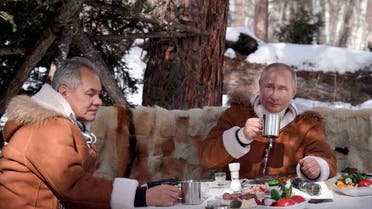 Russian President Vladimir Putin, right, and Russian Defense Minister Sergei Shoigu have a meal and drinks in a taiga forest in Russia’s Siberian region in Russia, Sunday, March 21, 2021. (Alexei Druzhinin, Sputnik, Kremlin Pool Photo via AP)