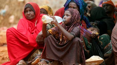 Internally displaced Somali women wait for relief food while a child drinks water at a distribution centre organized by a Qatar charity after fleeing from drought stricken regions in Baidoa, west of Somalia's capital Mogadishu. (File photo: Reuters)