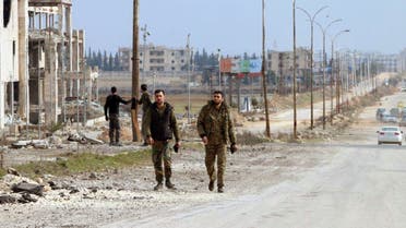 Syrian army soldiers walk along a street in Aleppo province, February 17, 2020. (Reuters)