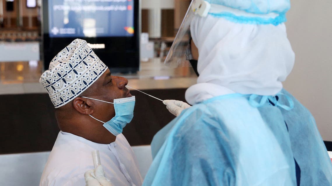 A medical worker collects a swab sample from a passenger for a RT-PCR Coronavirus test at the Muscat international airport in the Omani capital on October 1, 2020. (File photo: AFP)