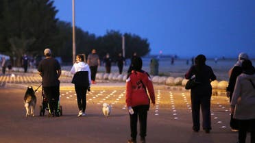 Residents walk on a waterfront promenade in Kuwait City on March 23, 2021, as authorities allowed people to exercise for two hours amid a nationwide curfew due to the COVID-19 pandemic. (File photo: AFP)