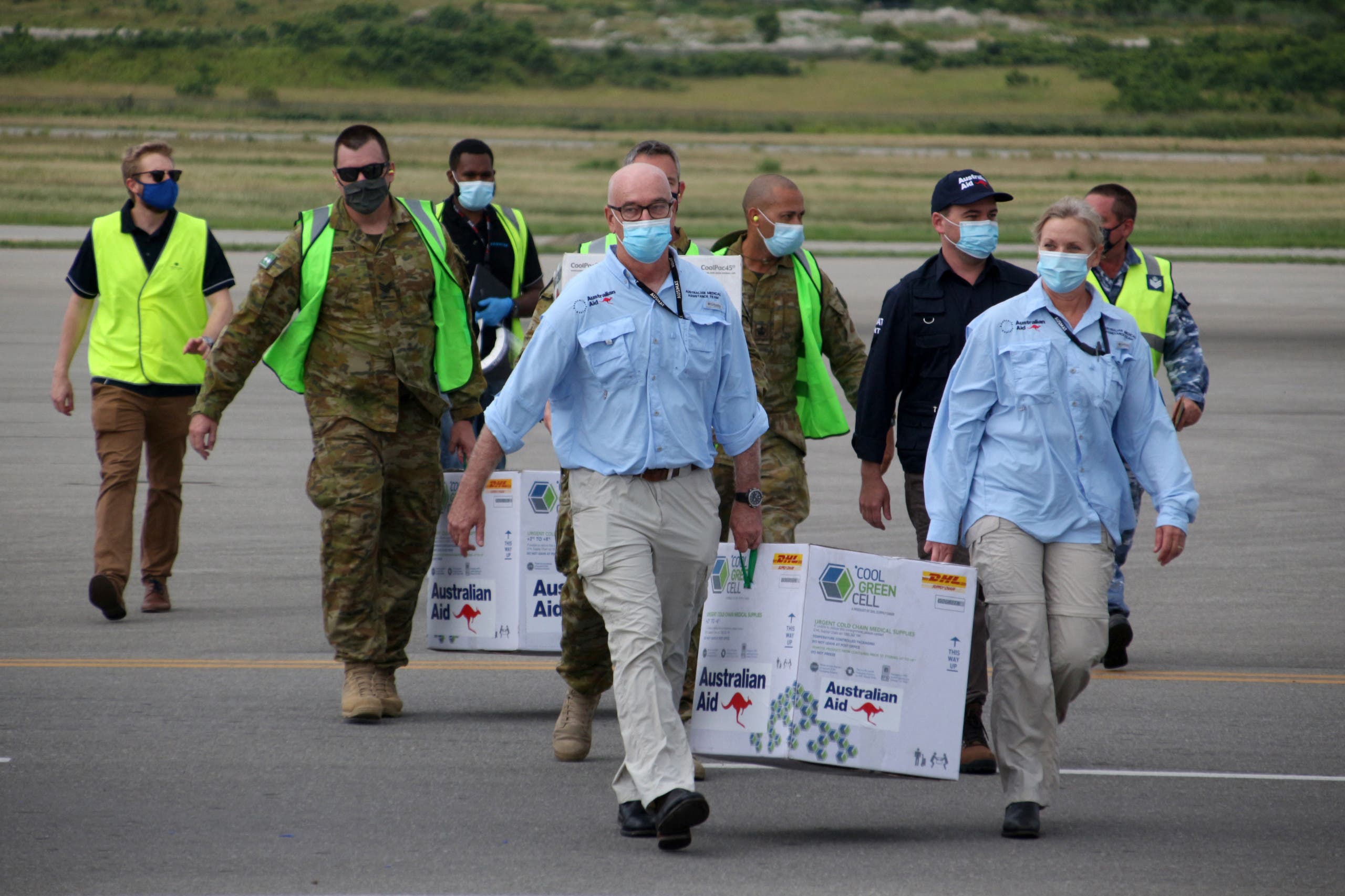 Australian officials carry boxes containing some 8,000 initial doses of the AstraZeneca vaccine following their arrival on board a Royal Australian Air Force plane at the Port Moresby international airport on March 23, 2021, as Papua New Guinea raced to quell a Covid-19 surge overwhelming its fragile health system. (File photo: AFP)