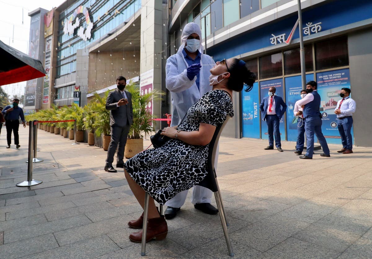 A healthcare worker collects a swab sample from a woman during a rapid antigen testing campaign for coronavirus, outside a shopping mall in Mumbai, India, on March 22, 2021. (Reuters)